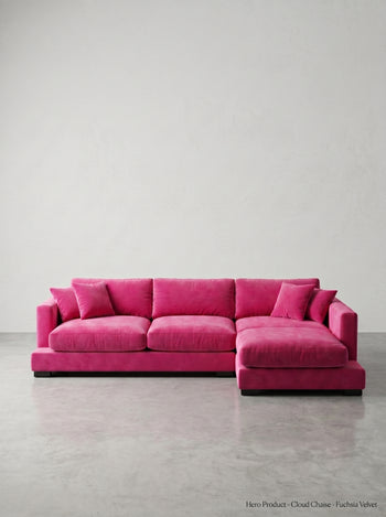 Pink sectional sofa on a gray floor with a white wall background